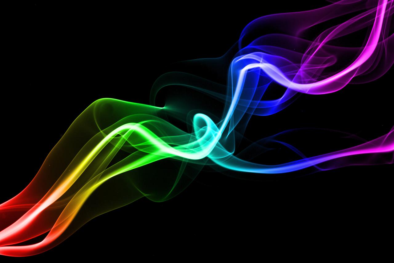 Digital illustration of smoke trail in rainbow colours isolated against a black background