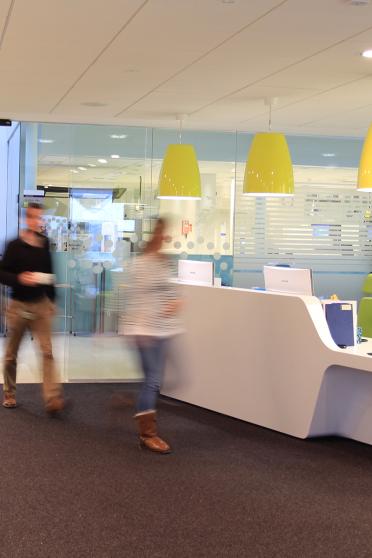 Reception area of the Earlham Institute with blurred people walking past