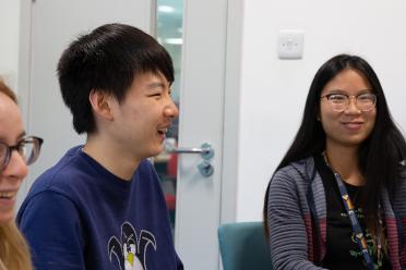 Colleagues from the Patron Group gathered around a table during their weekly lab meetings.