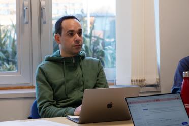 Karim Gharbi, Head of Genomics Pipelines sitting at his desk looking off to the side ofthe camera
