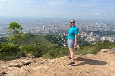 Kate standing atop a hill overlooking Cali in the background