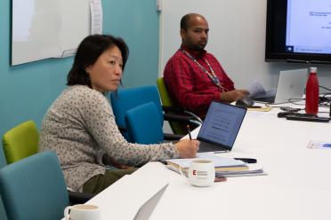 Dr Angela Man sitting at a table during a lab group meeting.