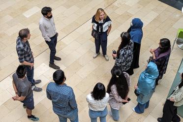 Prof Liz Wellington, Co-Lead on Gastropak talking to members of the group standing in a circle