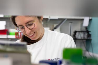 Dr Sarah Guiziou photographed through a gap in a lab bench