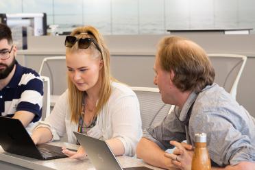 Anita Scoones and Iain Macaulay sitting together at a desk with their laptop screens in front of them