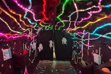 Inside the Microbe Zoo exhibition, shows a dark tunnel with LED multicoloured lights