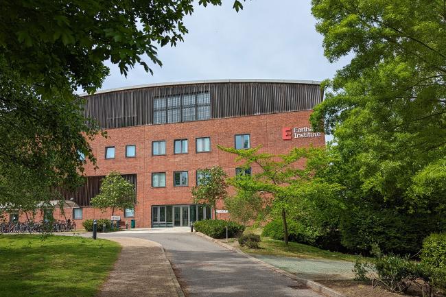 The outside of the Earlham Institute building with green trees in the foreground