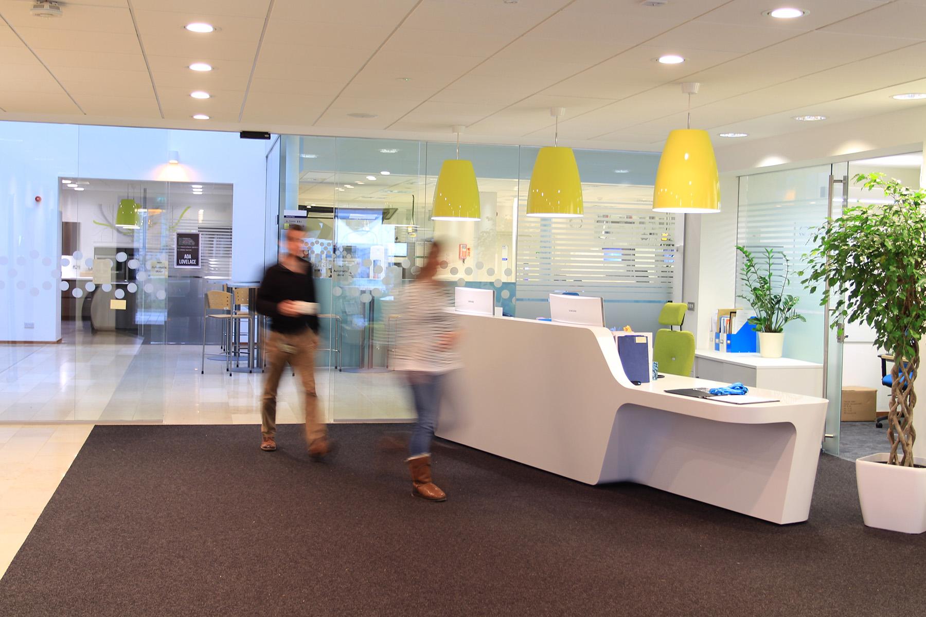 Reception area of the Earlham Institute with blurred people walking past